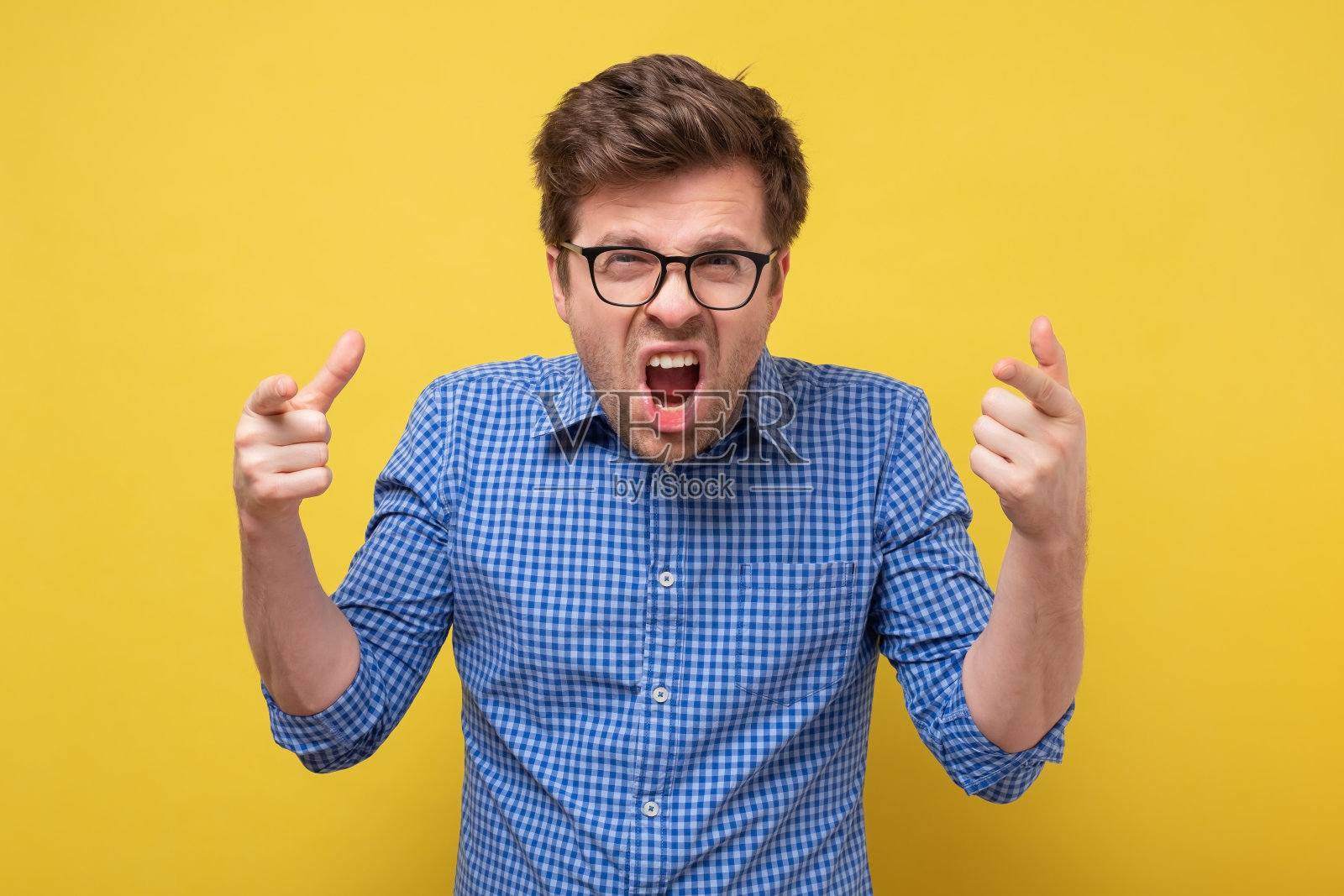 一个戴眼镜的白人在尖叫大喊。照片摄影图片