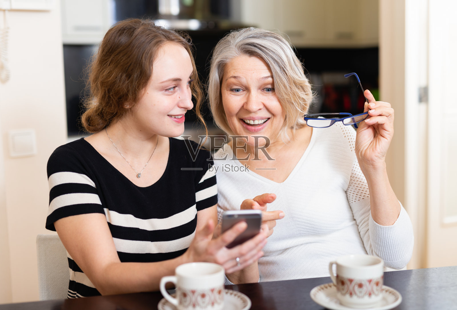 母亲和女儿使用智能手机照片摄影图片