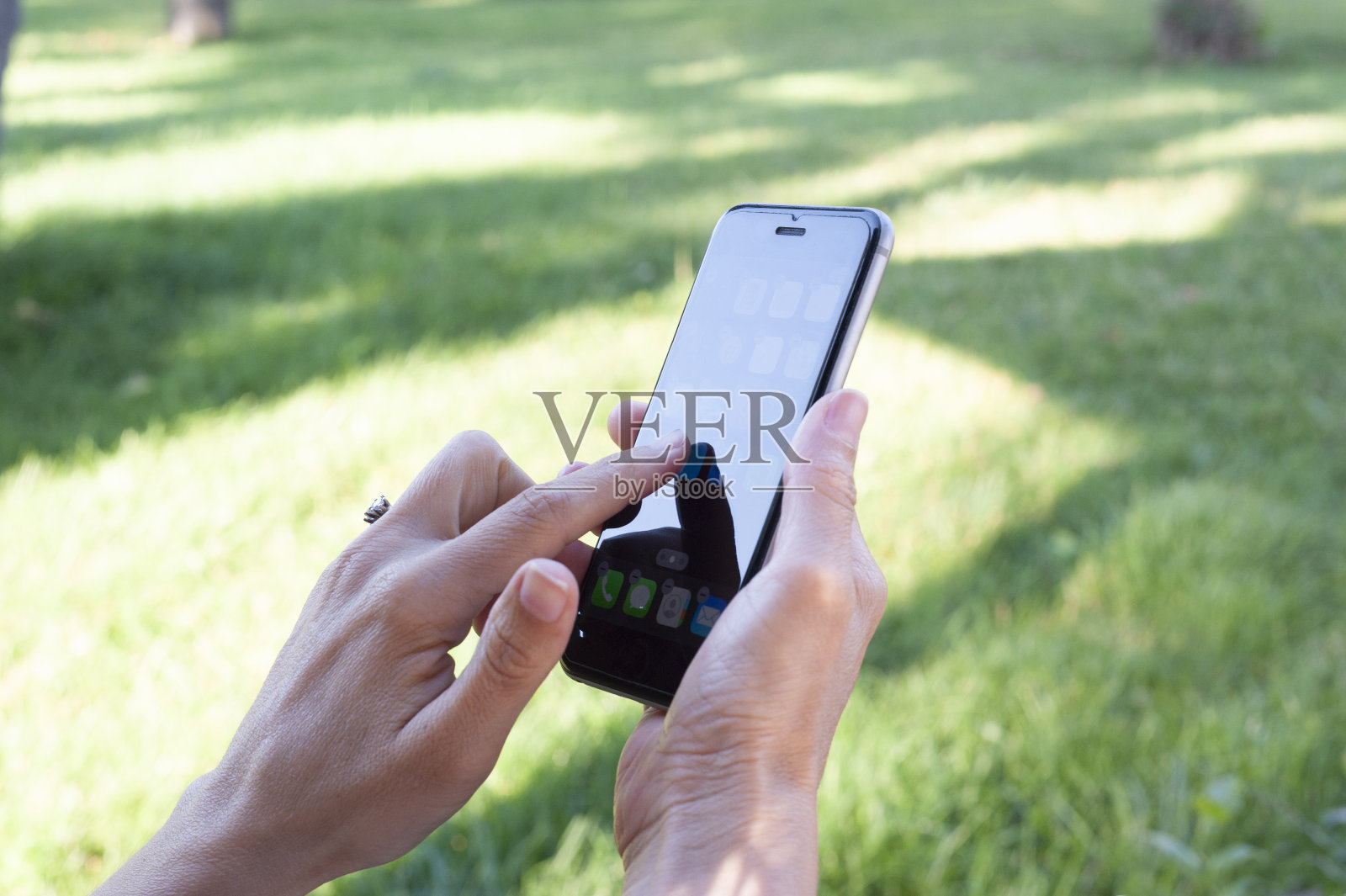 女人一边用手机，一边触摸屏幕。照片摄影图片