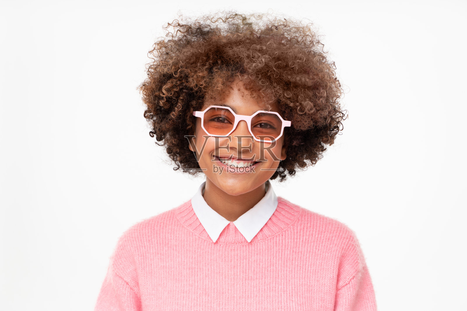 笑着的非洲女学生戴着粉红色的太阳镜，孤立在灰色的背景照片摄影图片