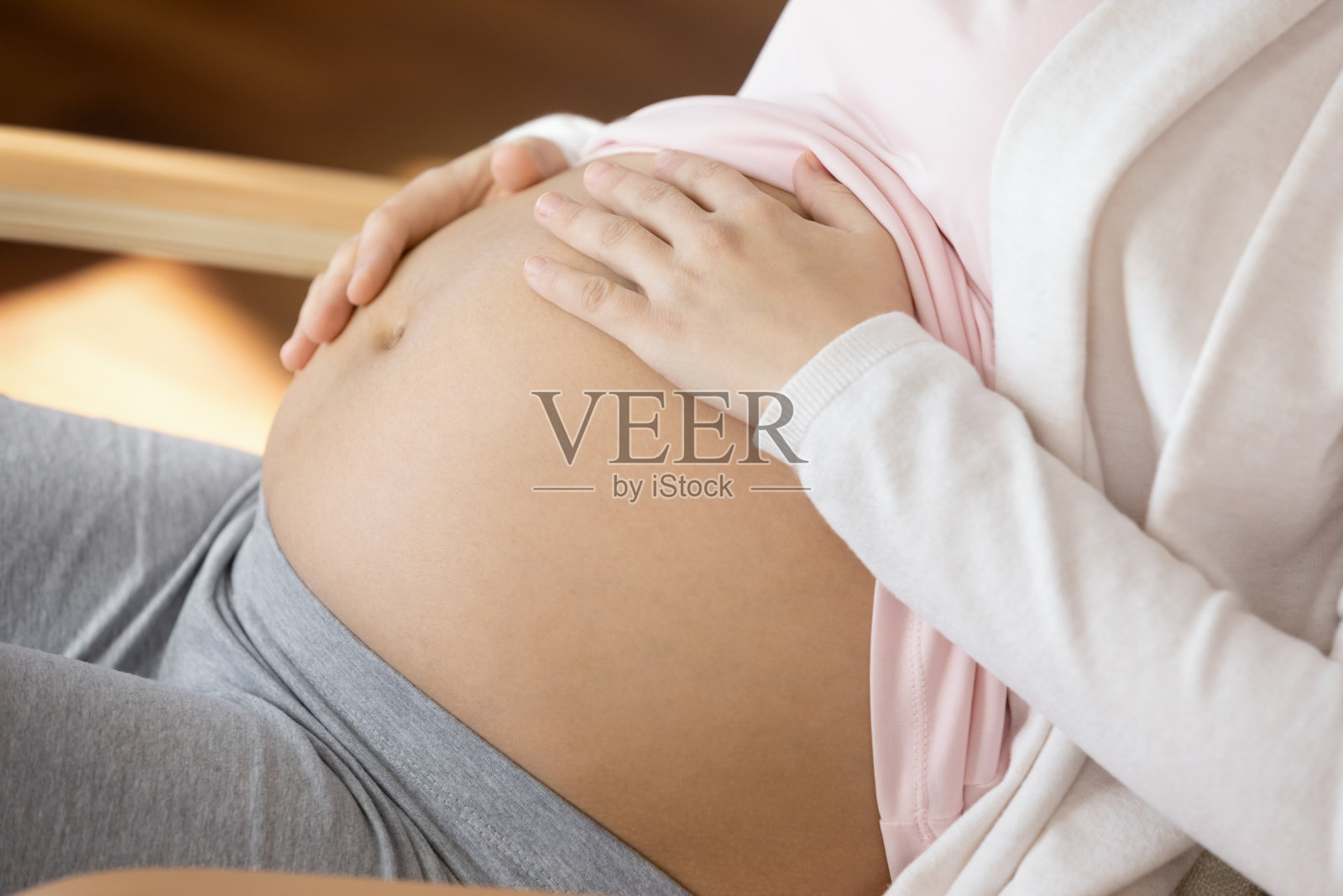 近裁孕妇触摸腹部，期待婴儿照片摄影图片