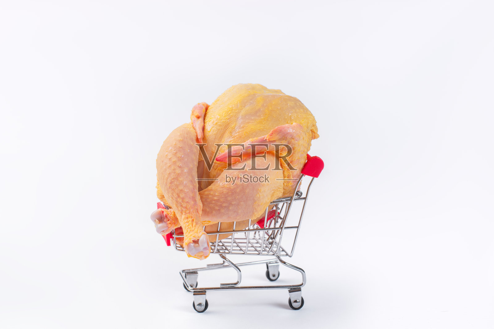 篮子里的新鲜生鸡肉。白色背景的超市手推车里的整只鸡。超市，减肥食品，白肉鸡肉，自由放养。照片摄影图片
