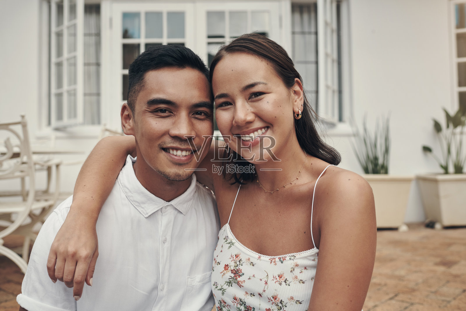 这是一对幸福的年轻夫妇在白天抱着对方坐在外面的照片照片摄影图片