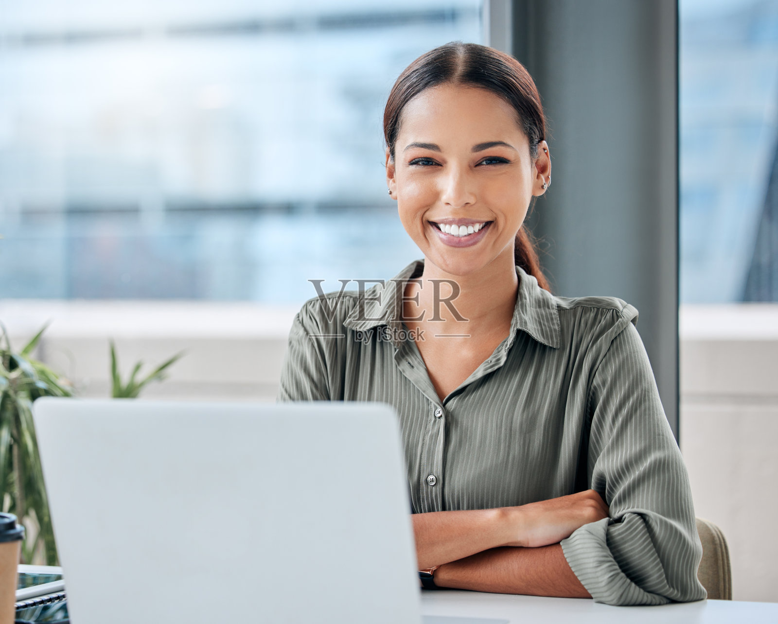 一个年轻的女商人在办公室用笔记本电脑工作的肖像照片摄影图片