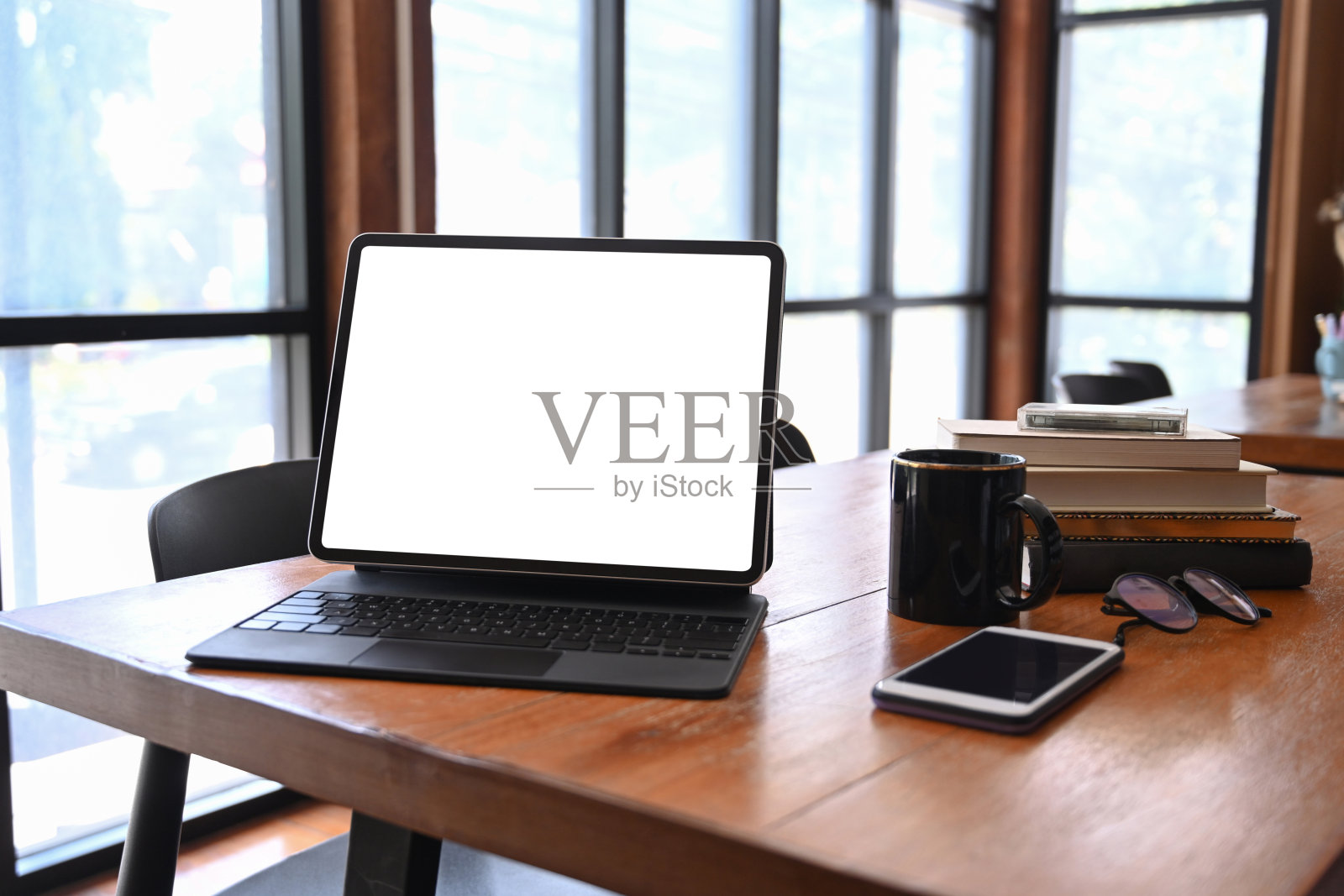 在木桌上模拟平板电脑、智能手机、书籍和咖啡杯。照片摄影图片