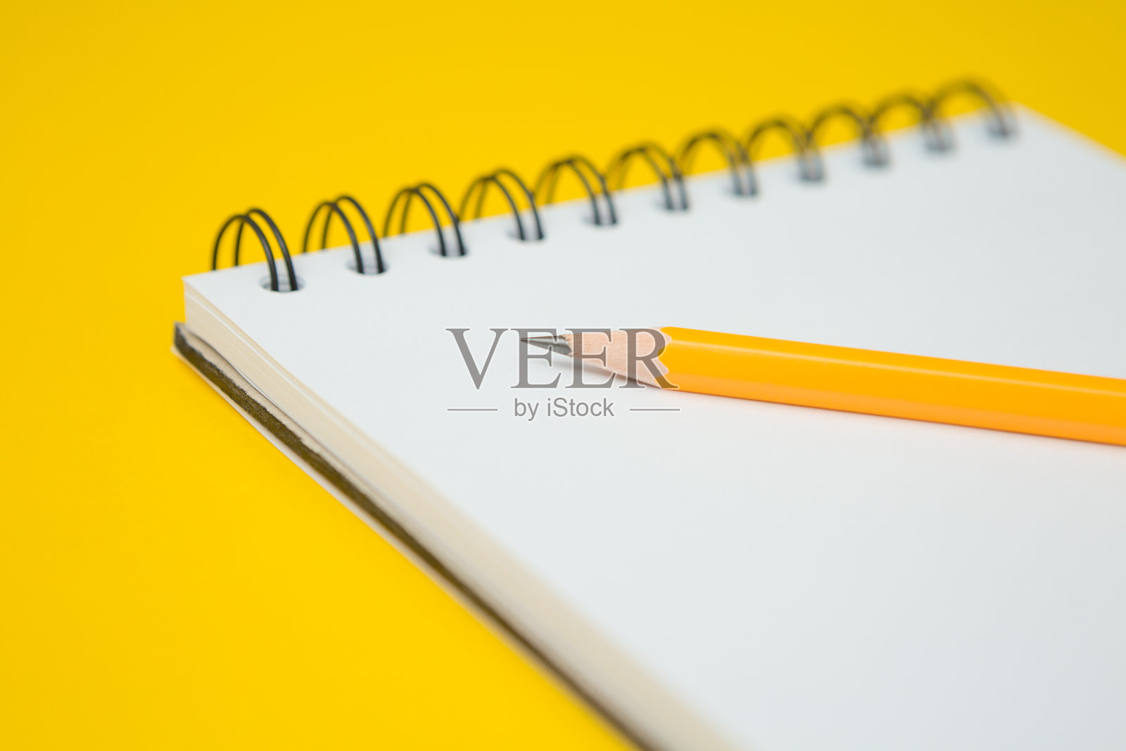 选择焦点笔记本，铅笔在一个黄色的背景和复制空间照片摄影图片