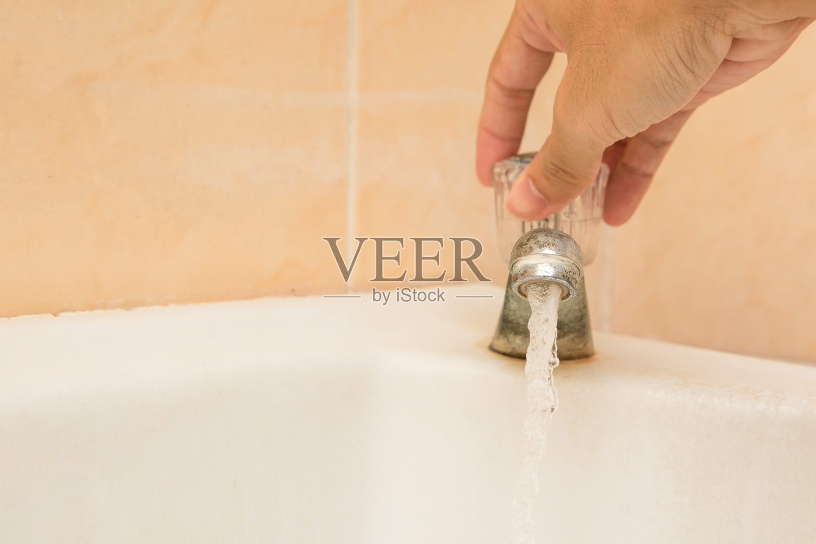 手扶着打开洗脸盆和复印空间上又旧又脏的水龙头照片摄影图片