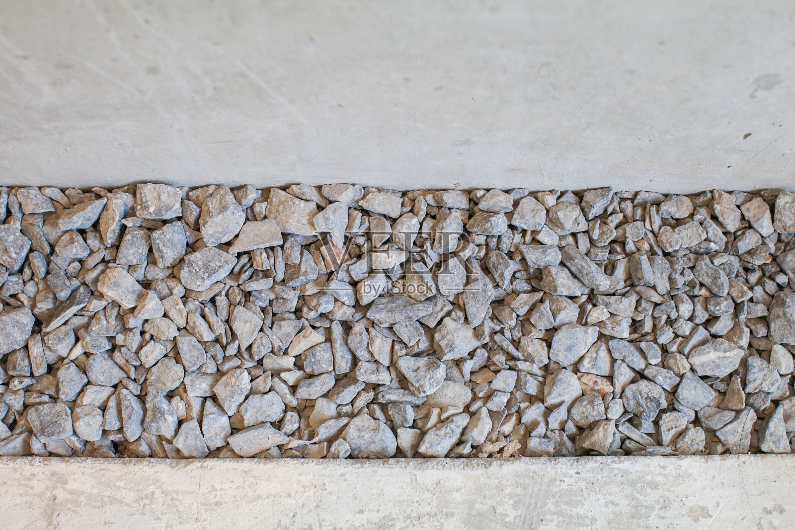 白色的碎石和混凝土板成两半。抽象的背景。部分混凝土人行道和碎石。外部或站点设计。照片摄影图片