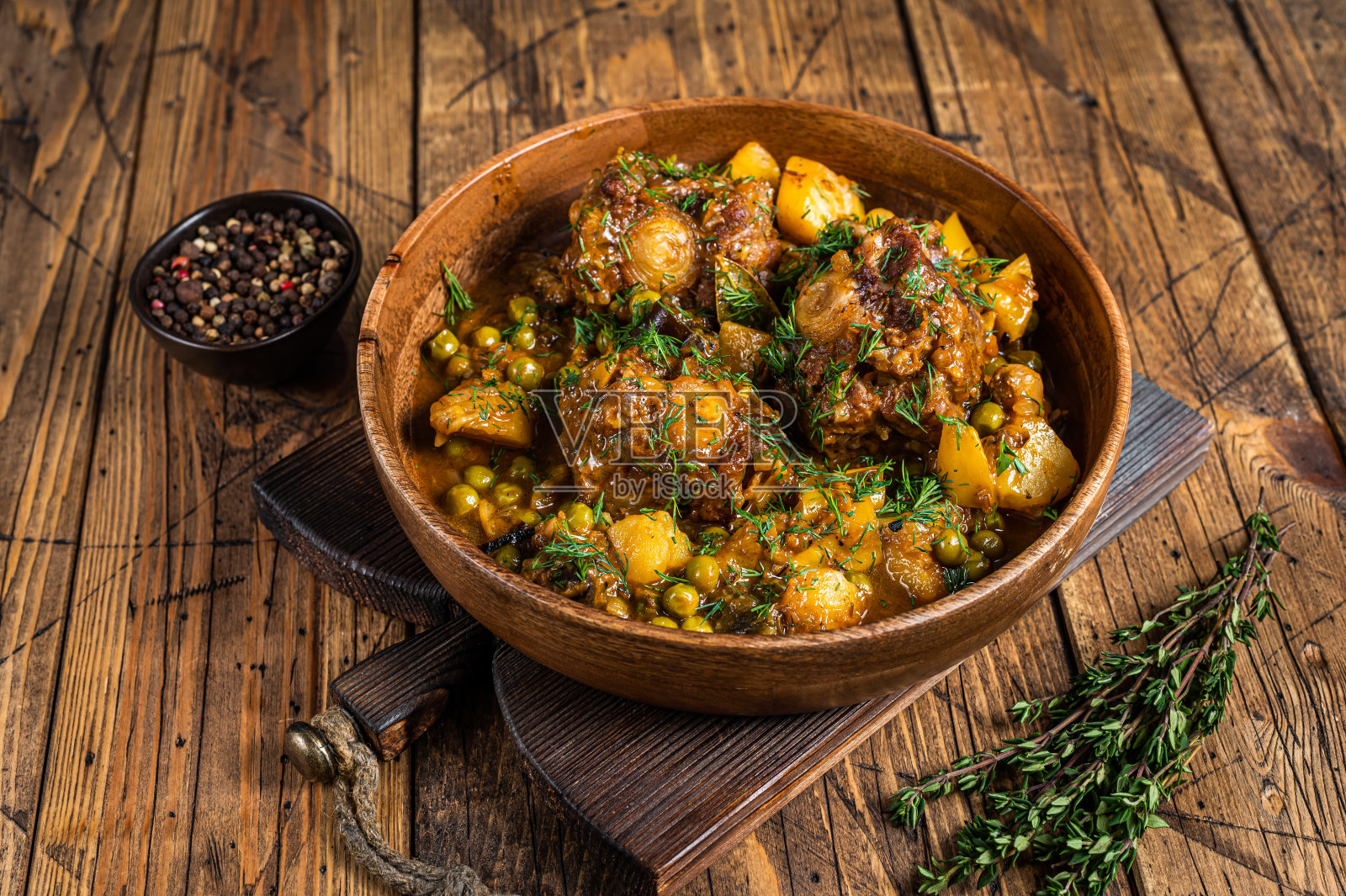 小牛肉、牛尾和蔬菜在木盘子里炖。木制背景。俯视图照片摄影图片