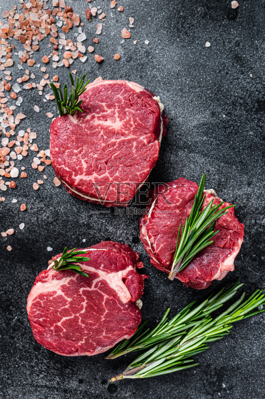 牛柳，里脊，生肉，牛肉排在屠宰桌上。黑色背景。俯视图照片摄影图片