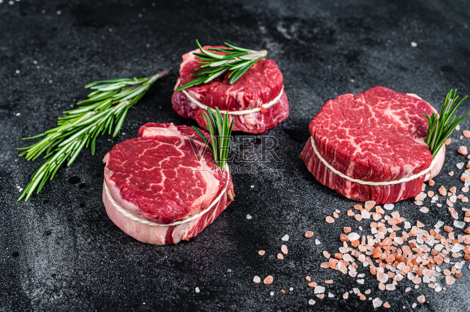 牛柳，里脊，生肉，牛肉排在屠宰桌上。黑色背景。俯视图照片摄影图片