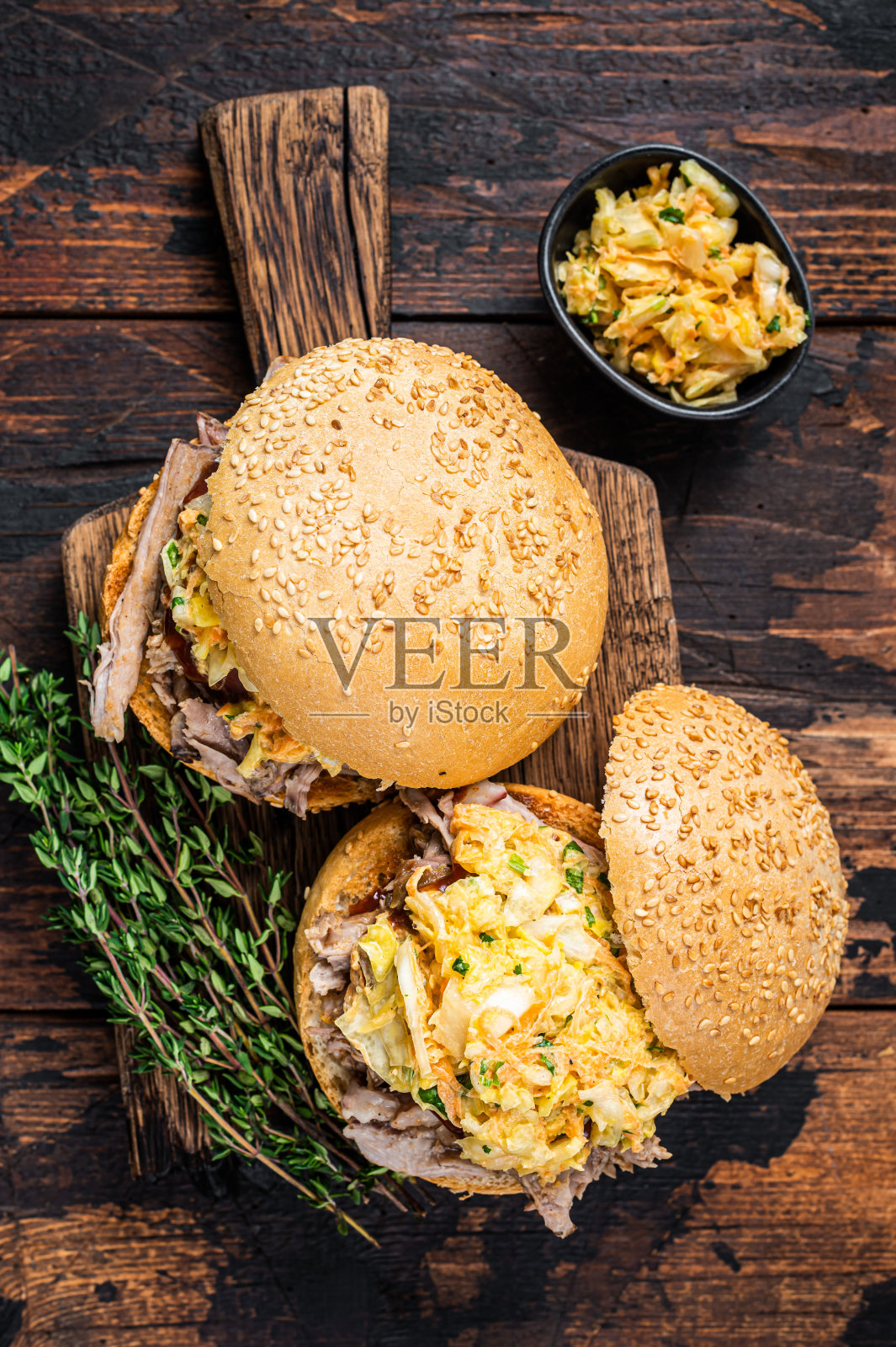 拉丝猪肉汉堡配烧烤酱和凉拌卷心菜沙拉。深色木制背景。俯视图照片摄影图片