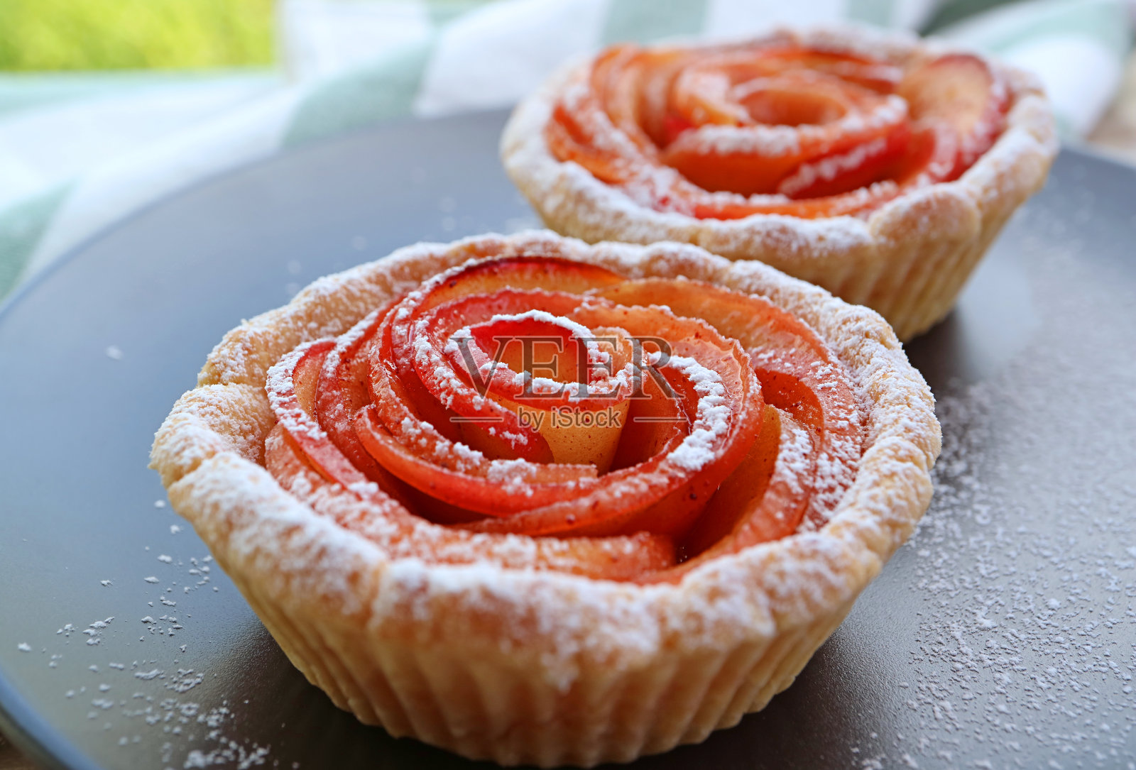 特写:令人垂涎的迷你苹果玫瑰馅饼在一个黑色的盘子照片摄影图片