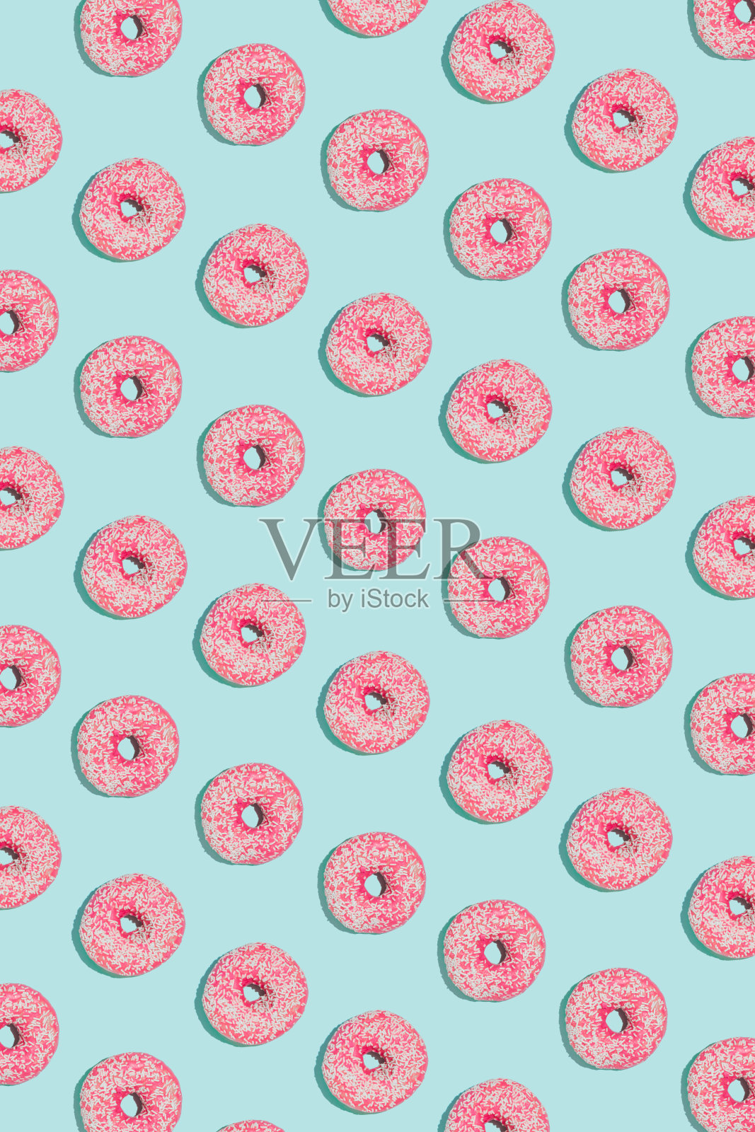 夏天与亮蓝色背景上的粉色甜甜圈图案创意。简约的几何排列，快乐阳光的概念。平面构成。照片摄影图片