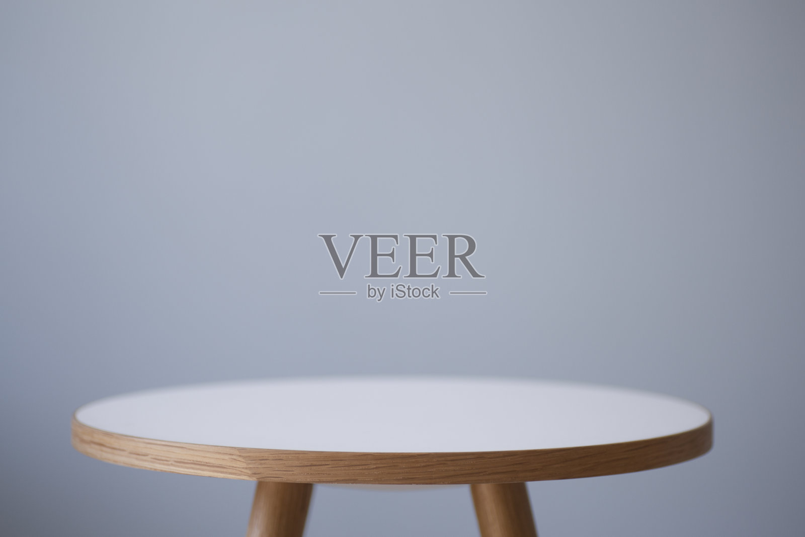 背景表。室内的圆形咖啡桌，背景是一面明亮的空墙。照片摄影图片