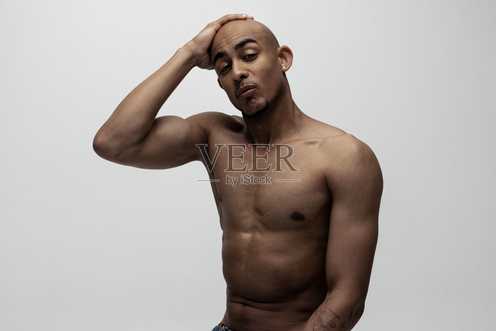 年轻英俊的肌肉发达的非洲男子摆出孤立的白色背景。美容、化妆品、水疗的概念。照片摄影图片