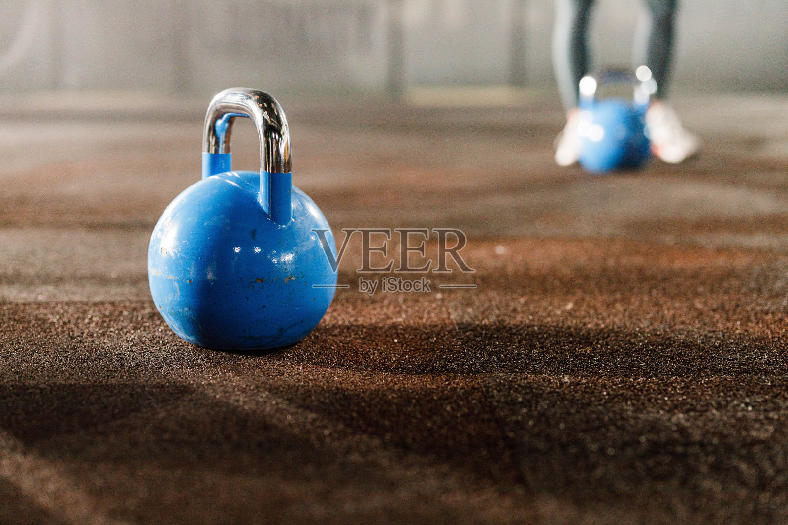 近距离观察健身房里的蓝色茶壶铃。照片摄影图片