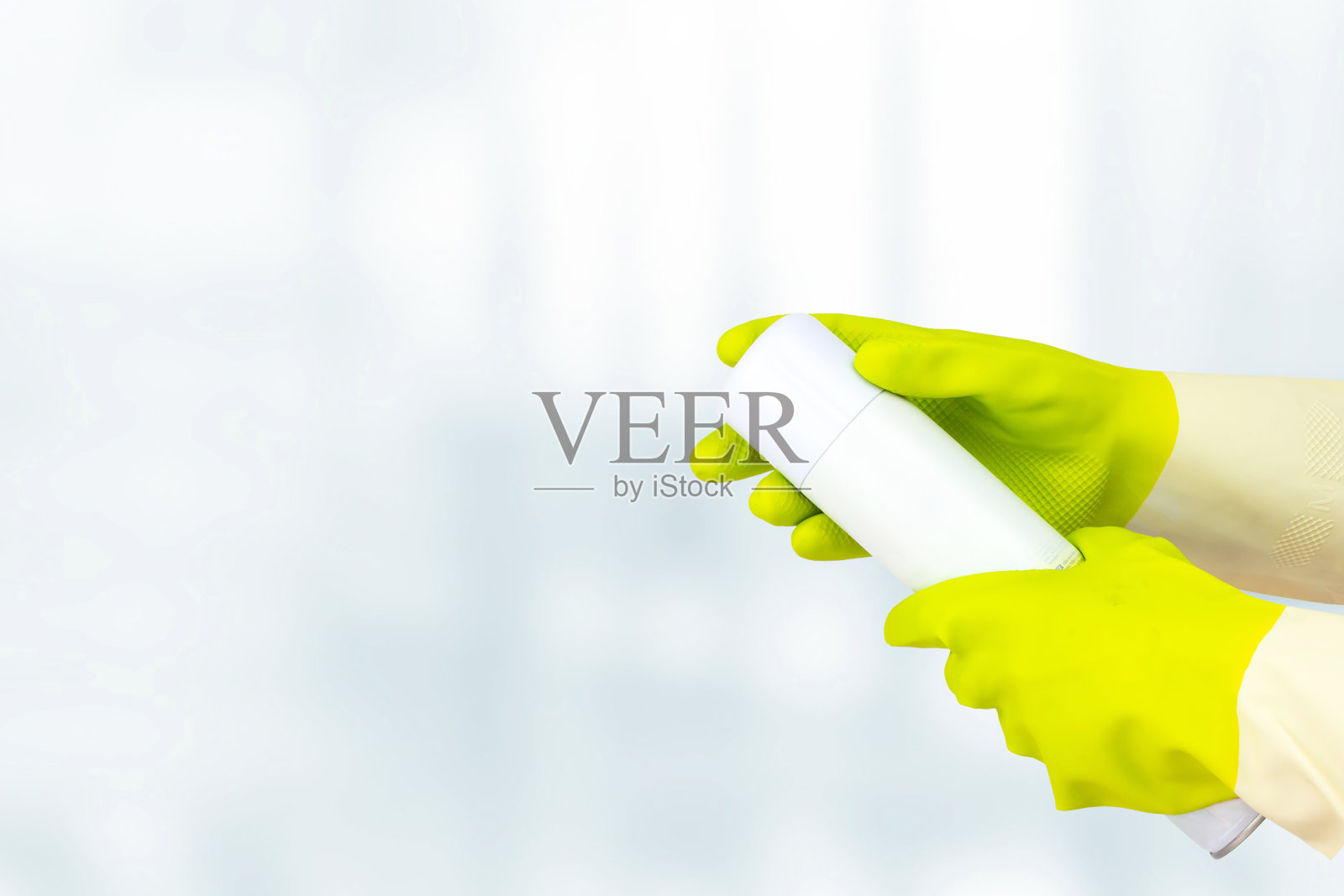 春季大扫除的概念。俯视图黄色橡胶手套手拿喷空气清新剂。保洁理念，保洁服务。照片摄影图片