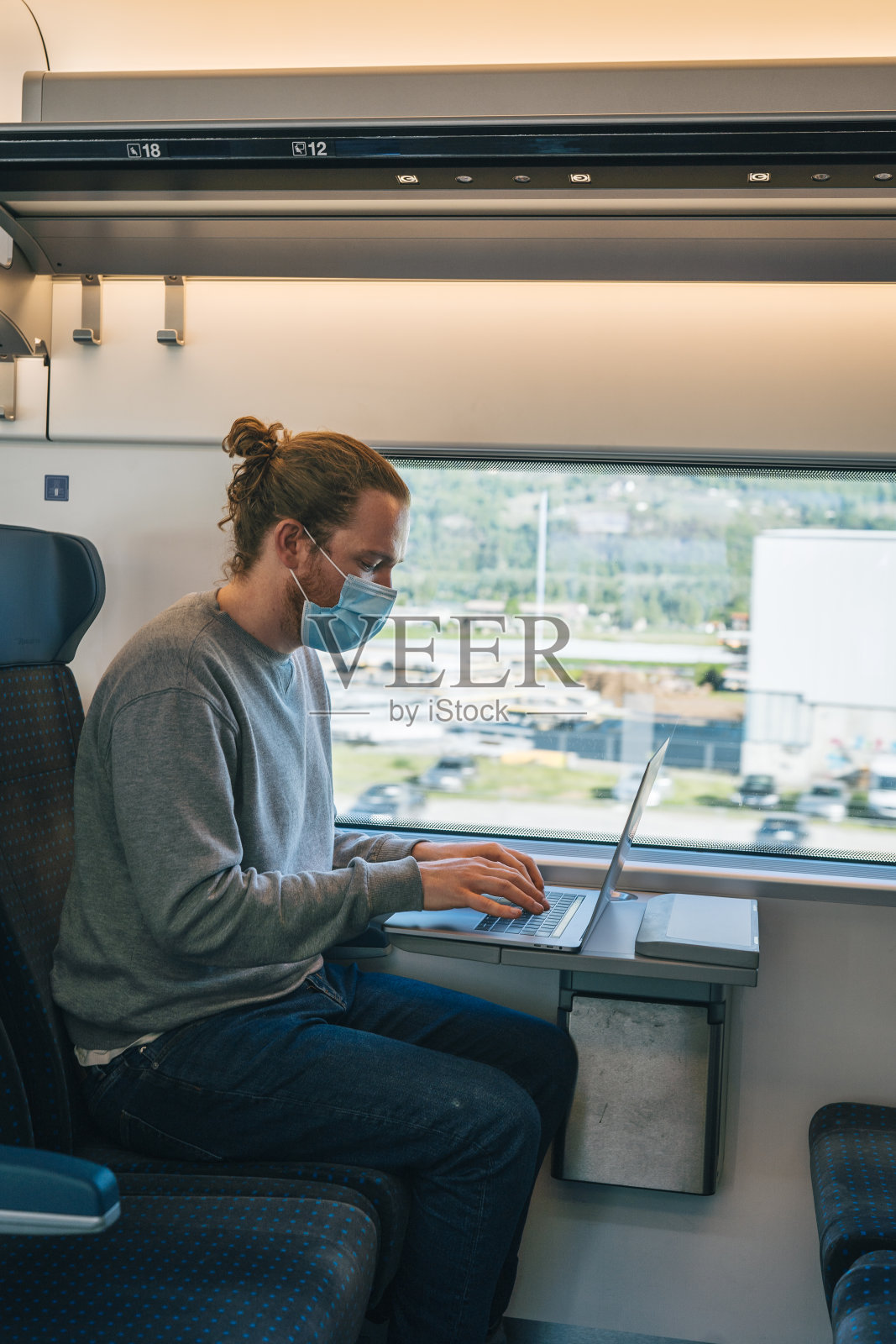 年轻人坐在火车上用笔记本电脑工作照片摄影图片