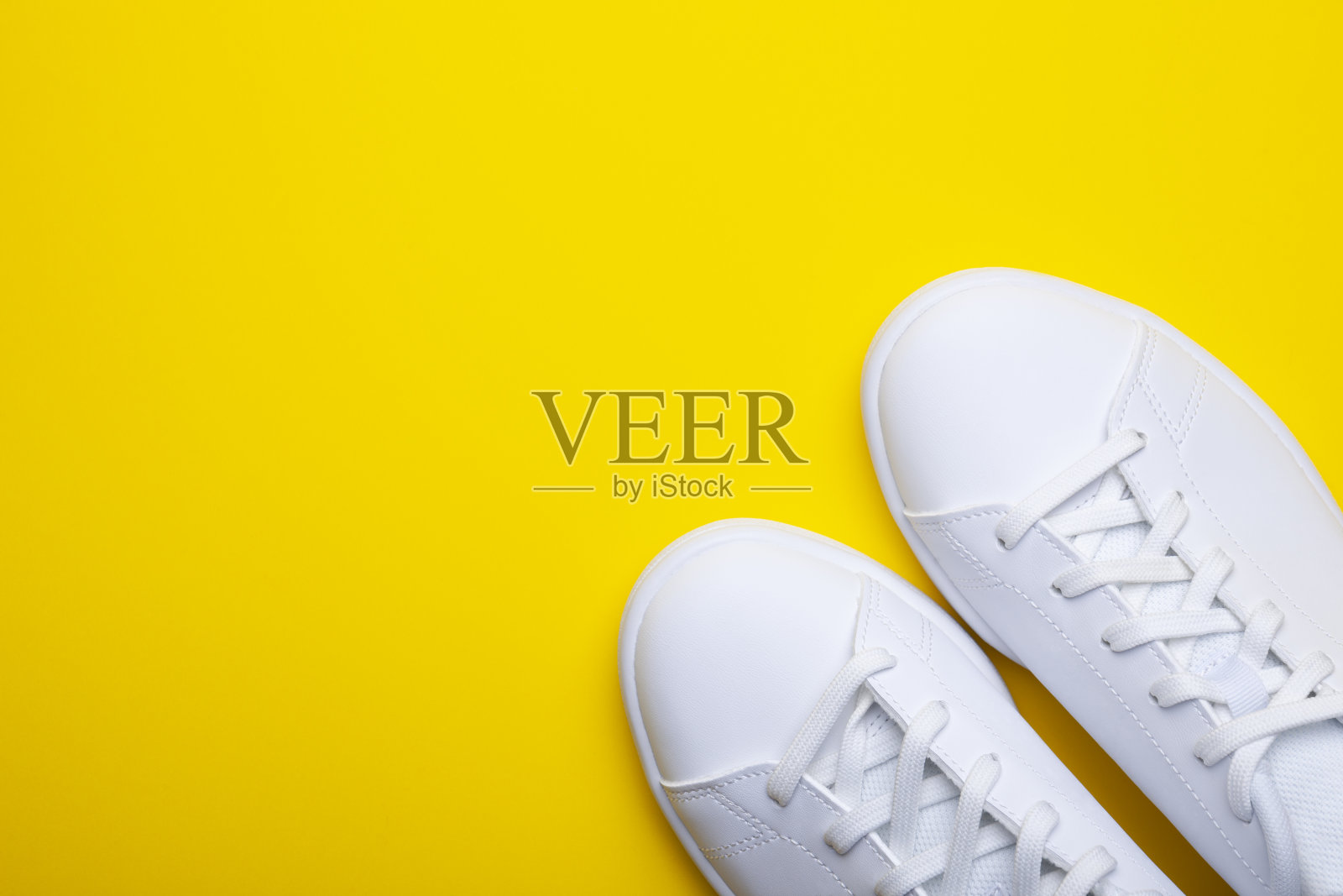 一双黄色背景的休闲鞋。顶视图时尚运动鞋的颜色背景与地方的文本照片摄影图片