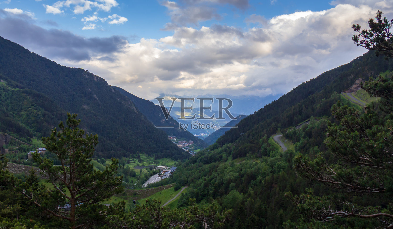 从山林中俯瞰一个村庄，在蓝天下照片摄影图片