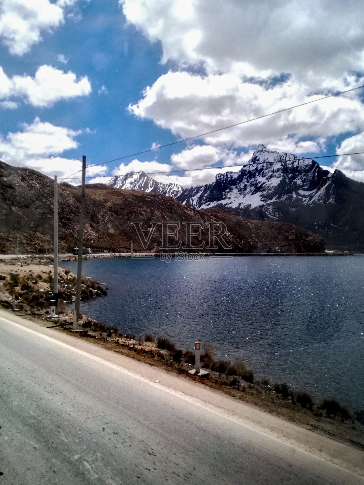 山上有雪，右边有湖照片摄影图片