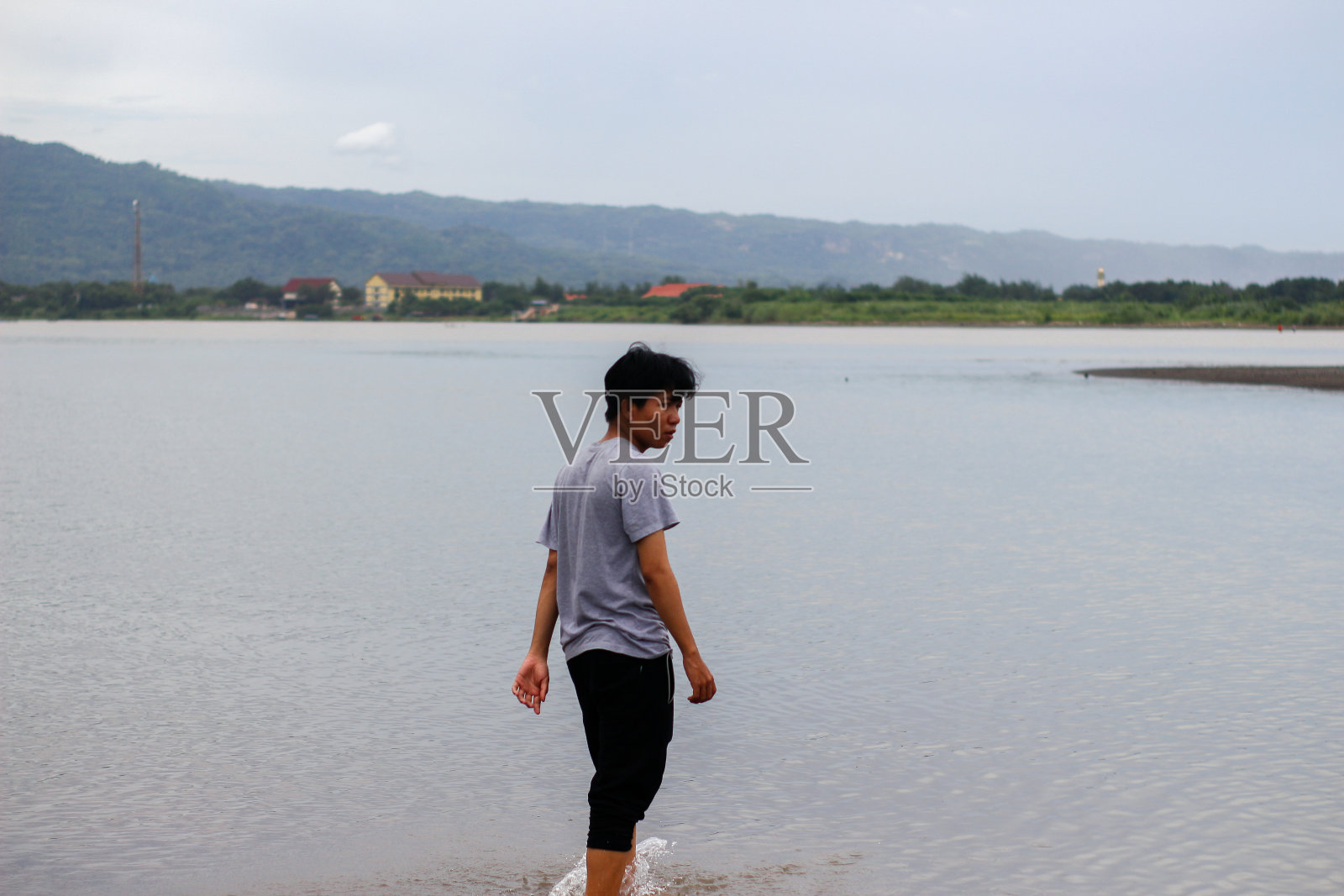 印度尼西亚少年独自在湖里玩照片摄影图片