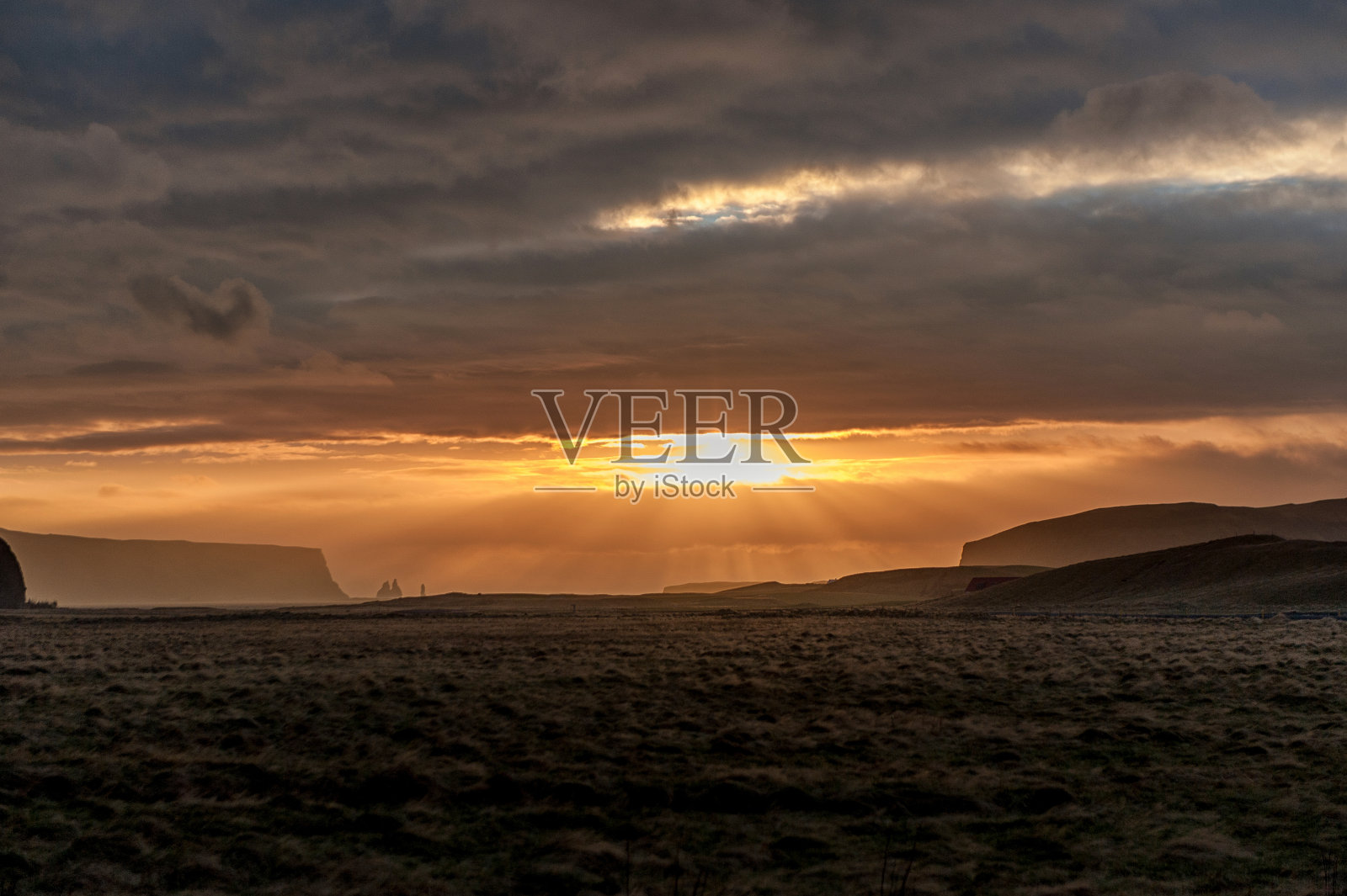 冰岛的清晨日出。多云的天空。阳光在云层之上。黑暗的场景照片摄影图片