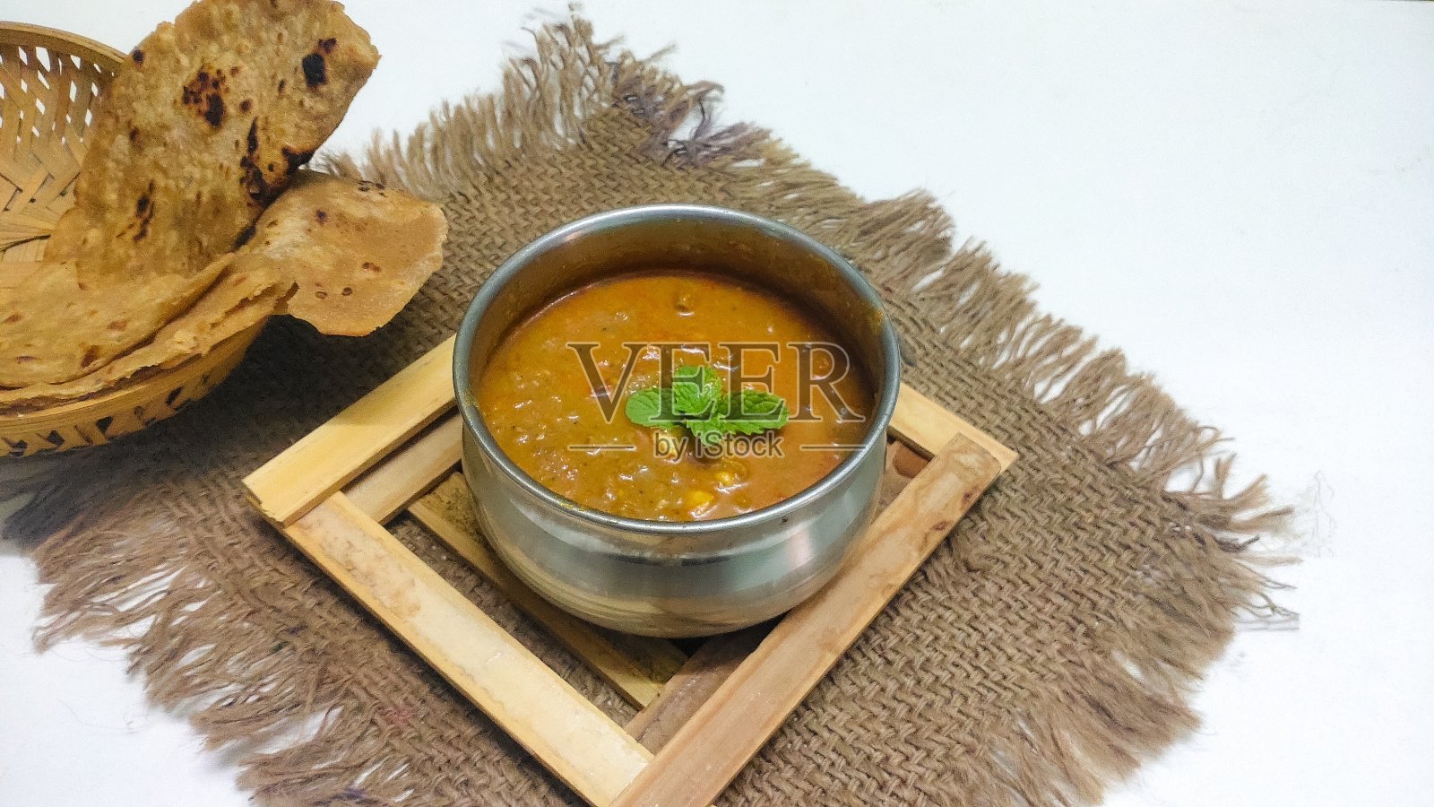 健康的印度菜Chapathi和肉汁的特写放置在一个孤立的白色背景与选择性的焦点和复制空间的铭文。照片摄影图片