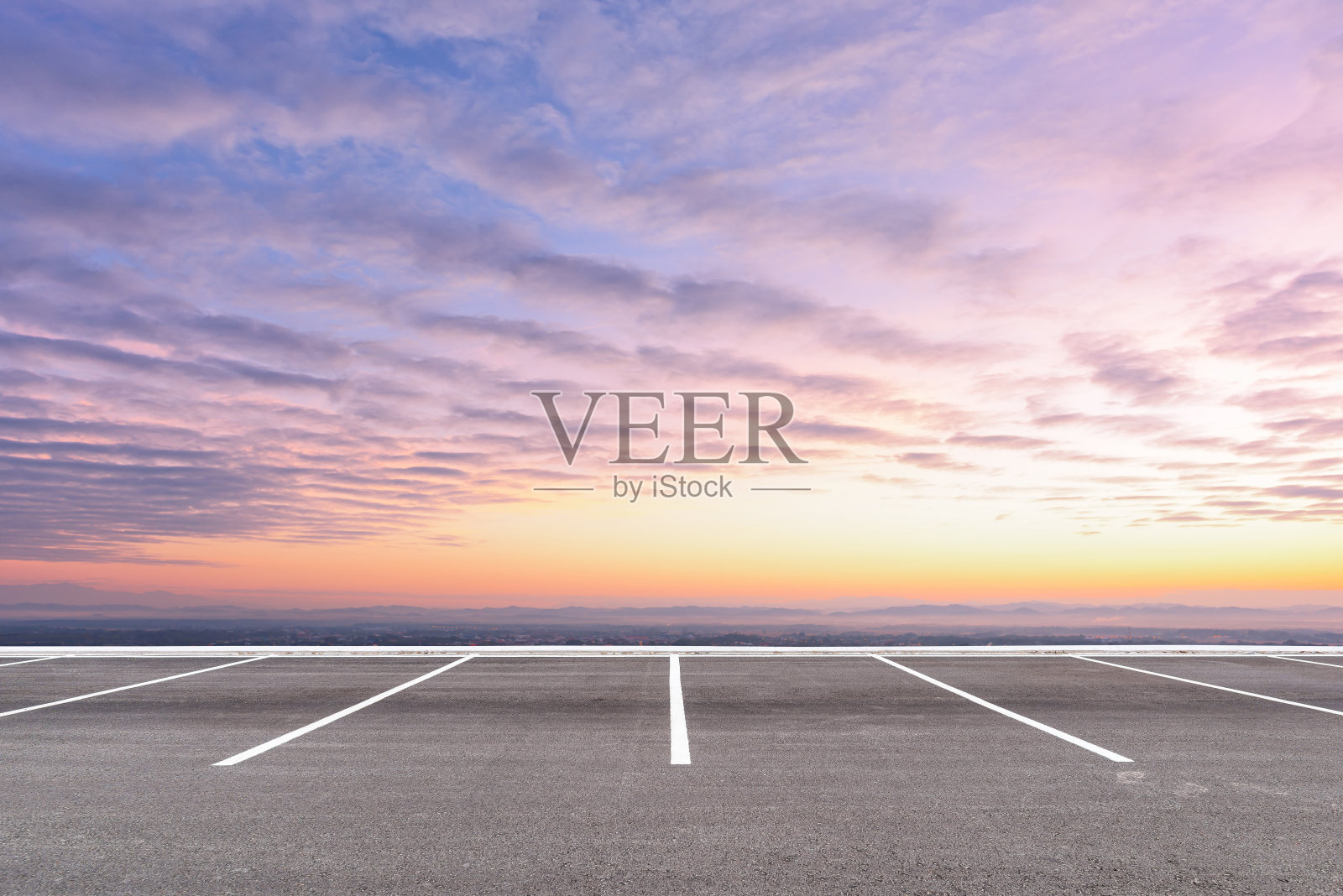 空旷的停车场映衬着美丽的日落天空。照片摄影图片