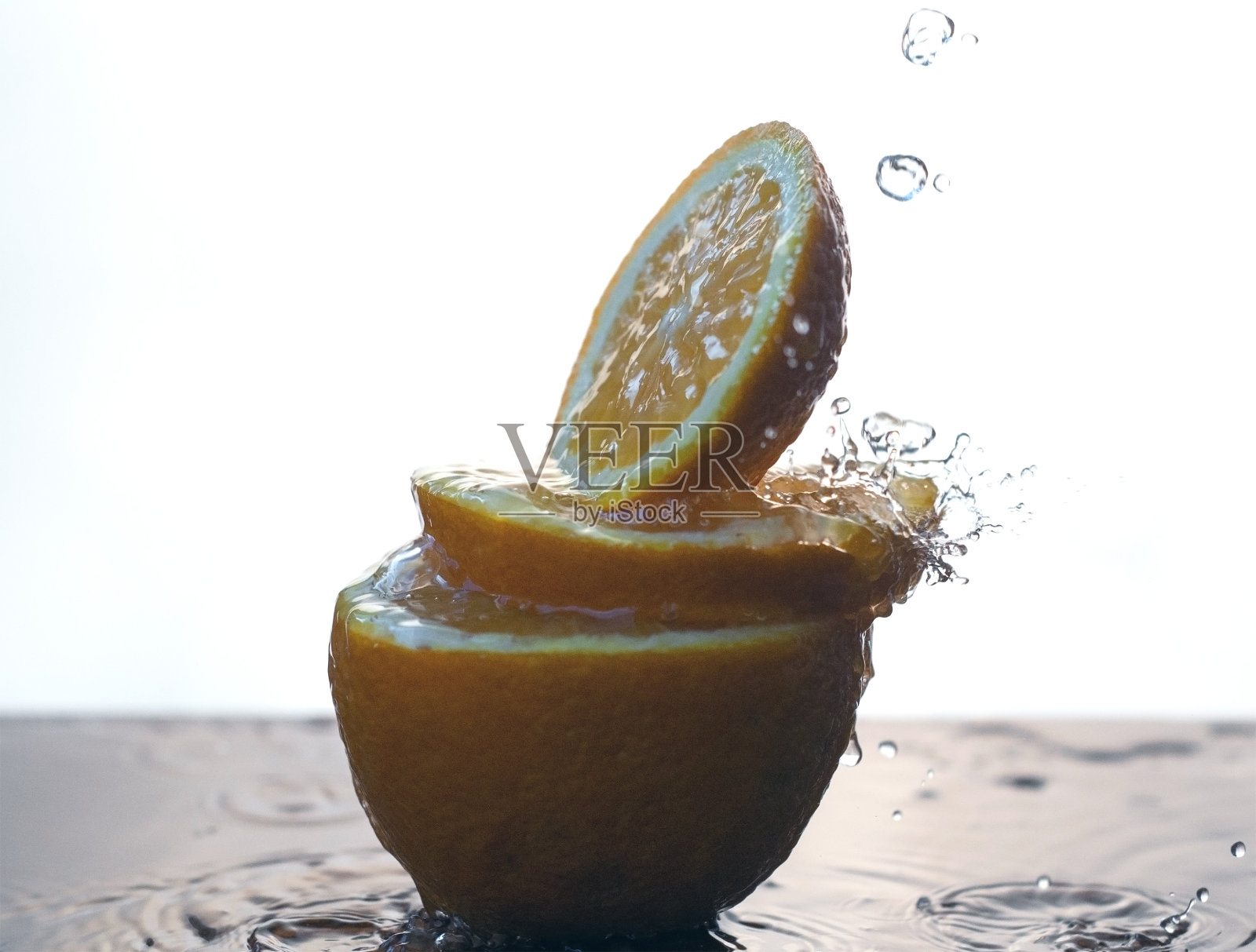 将水倒在切片的橘子上。一个在白色背景上切过的水果的特写。照片摄影图片