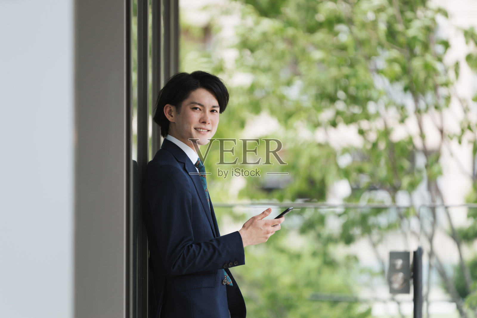 年轻人和商人看着智能手机来上班，做物联网照片摄影图片