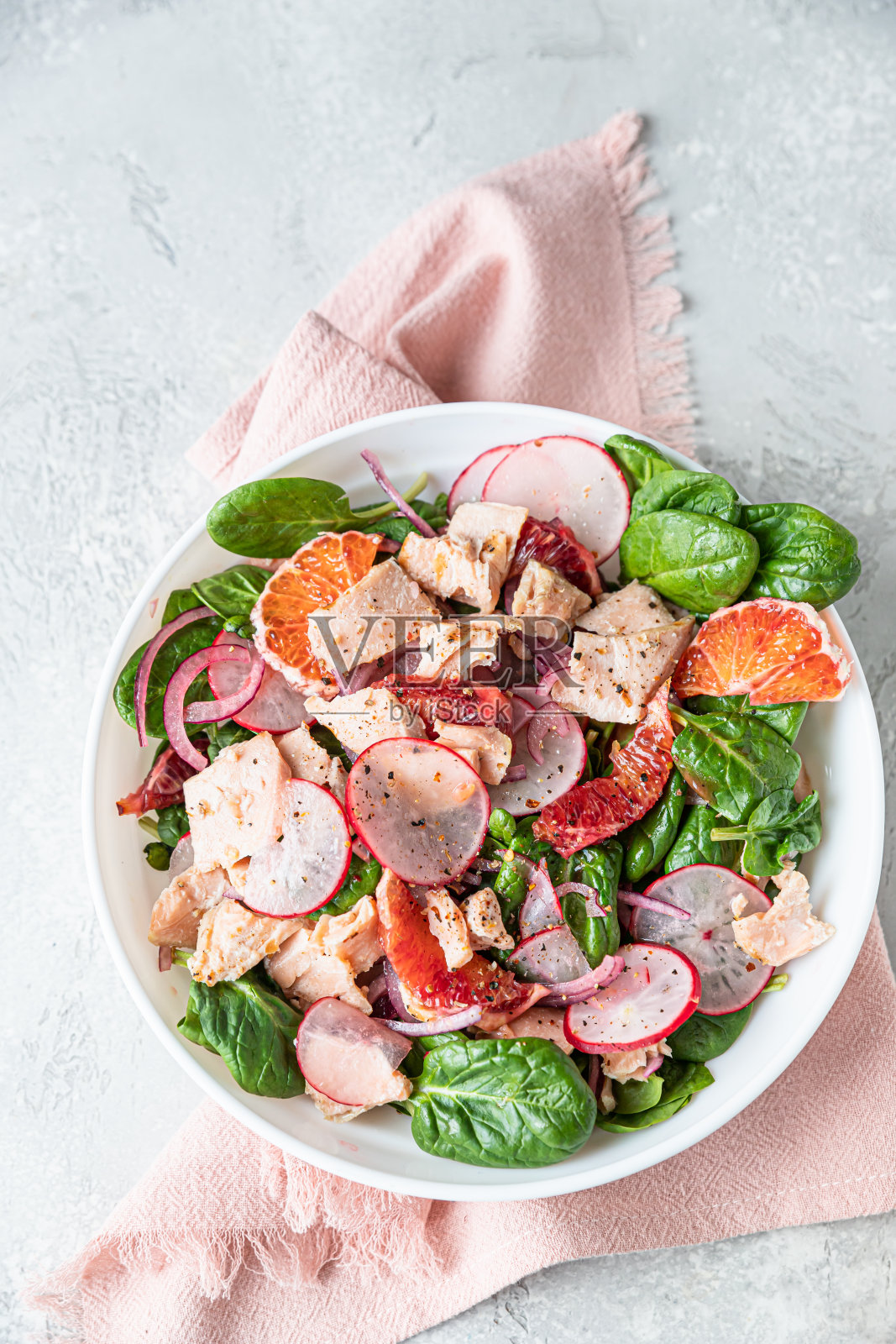 菠菜沙拉，烤鲑鱼，萝卜和西西里红橙。一个美味和健康的食物概念。前视图。照片摄影图片