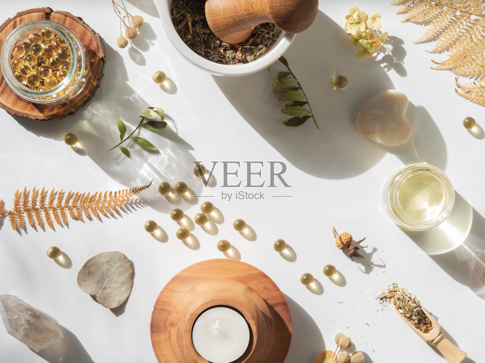 有机天然产品-油和各种干燥植物对健康的白色背景下的阳光照片摄影图片