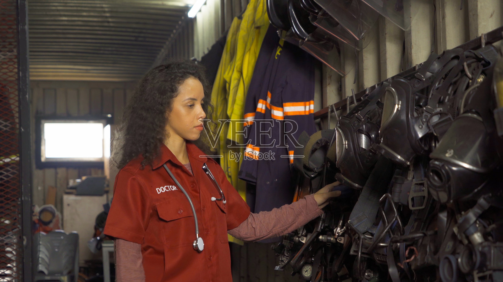 一名身穿制服的白种急救女医生在消防站的设备仓库检查设备的安全性和安全性，一次紧急事故的救援。人。服务工作照片摄影图片