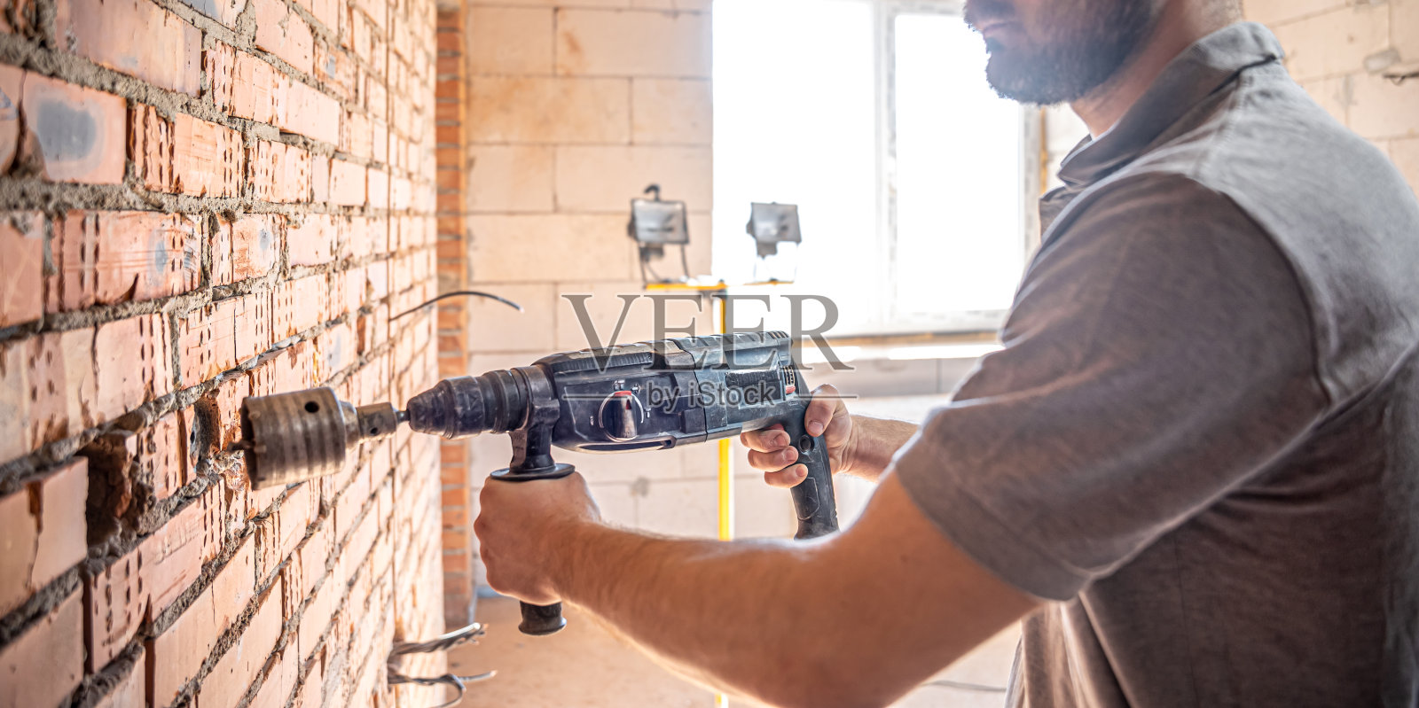 建筑工人们在建筑工地用钻头工作。照片摄影图片