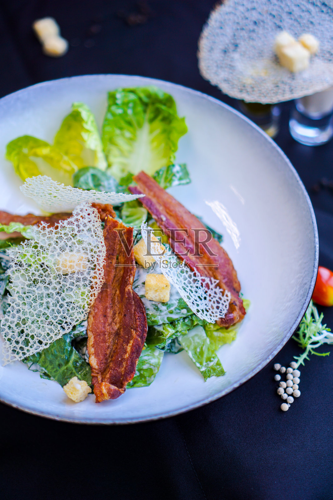 凯撒沙拉配培根，黑色背景照片摄影图片