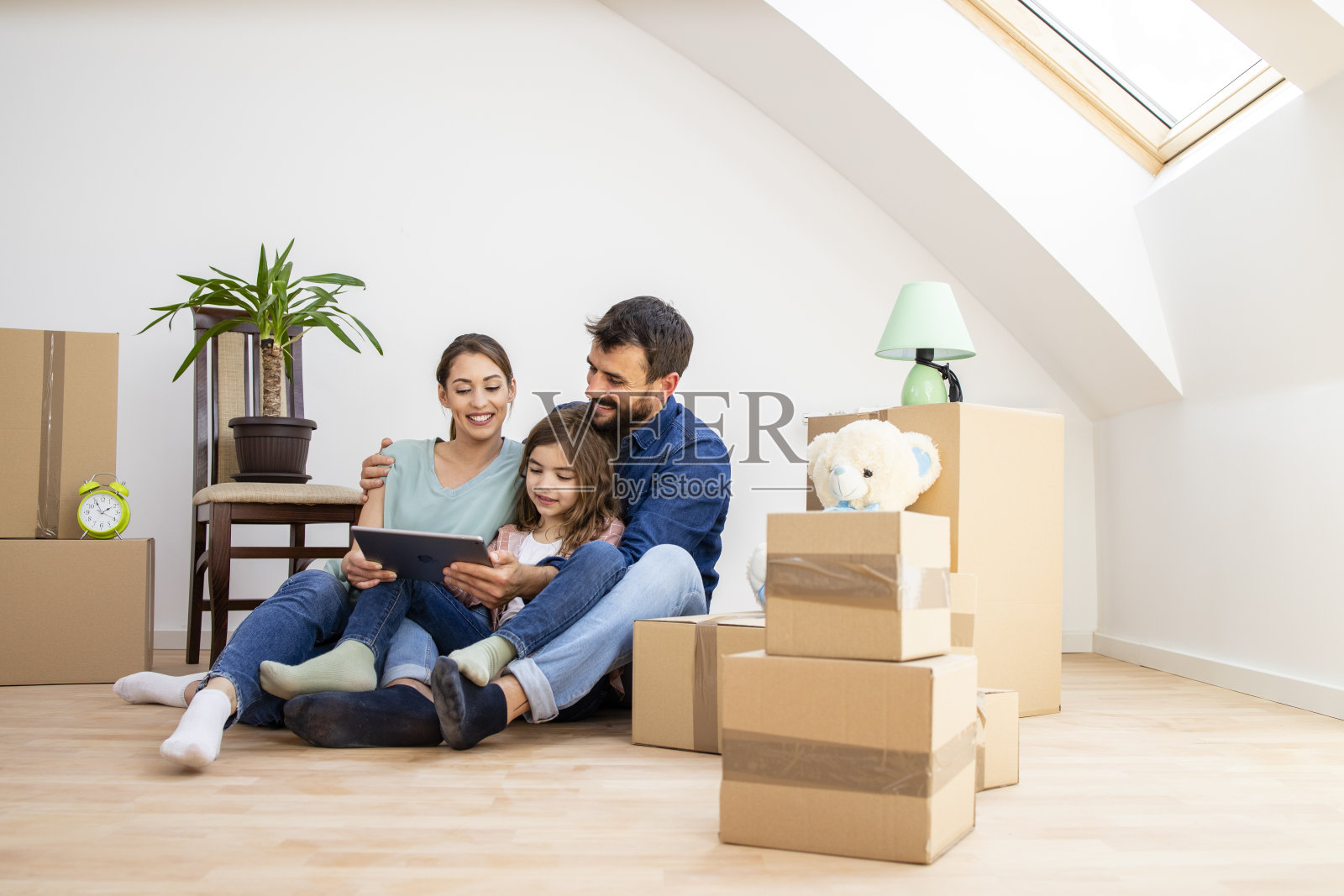 家居搬家理念——幸福家庭在平板电脑上选择家居室内设计。照片摄影图片