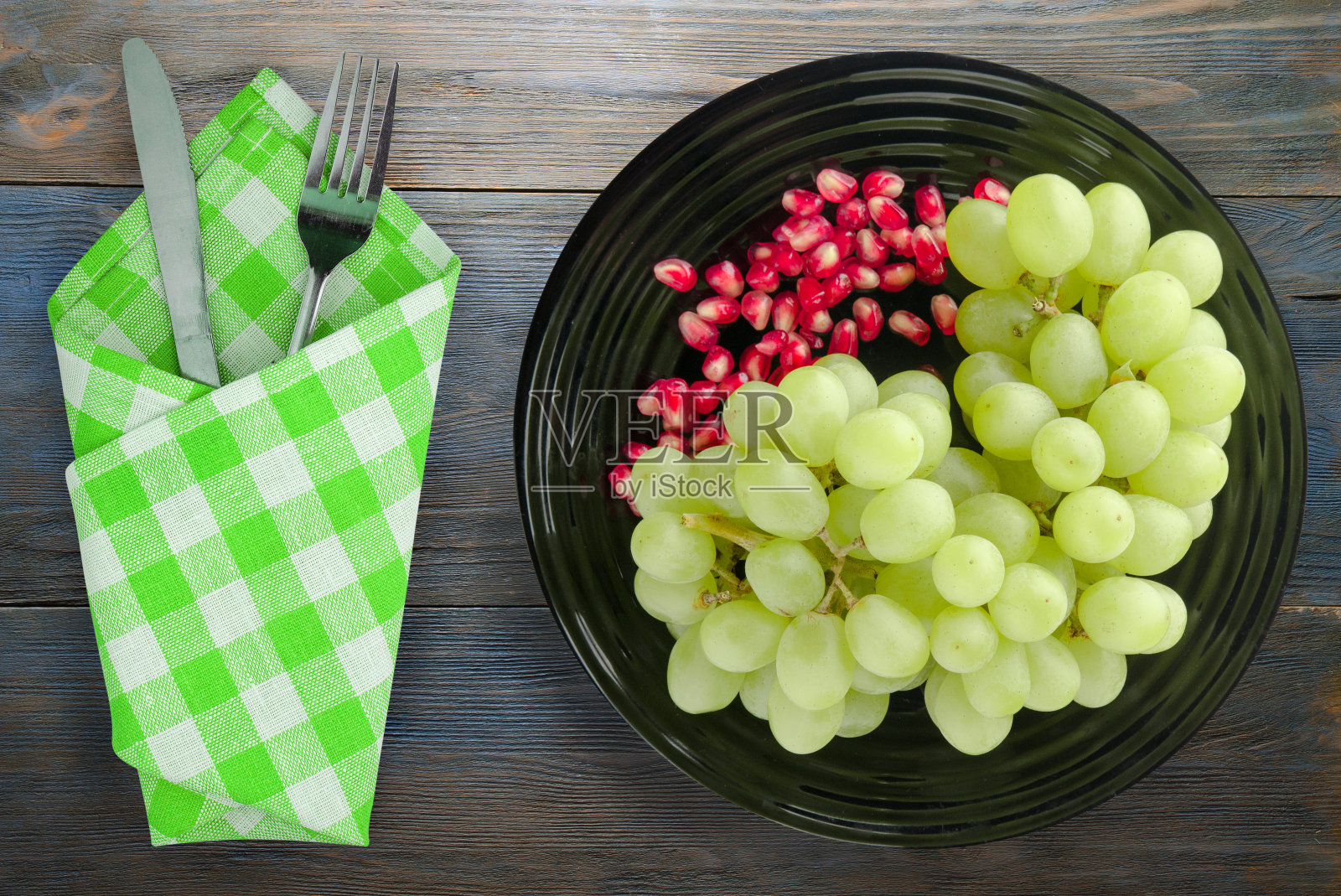 葡萄，石榴，木背景。照片摄影图片