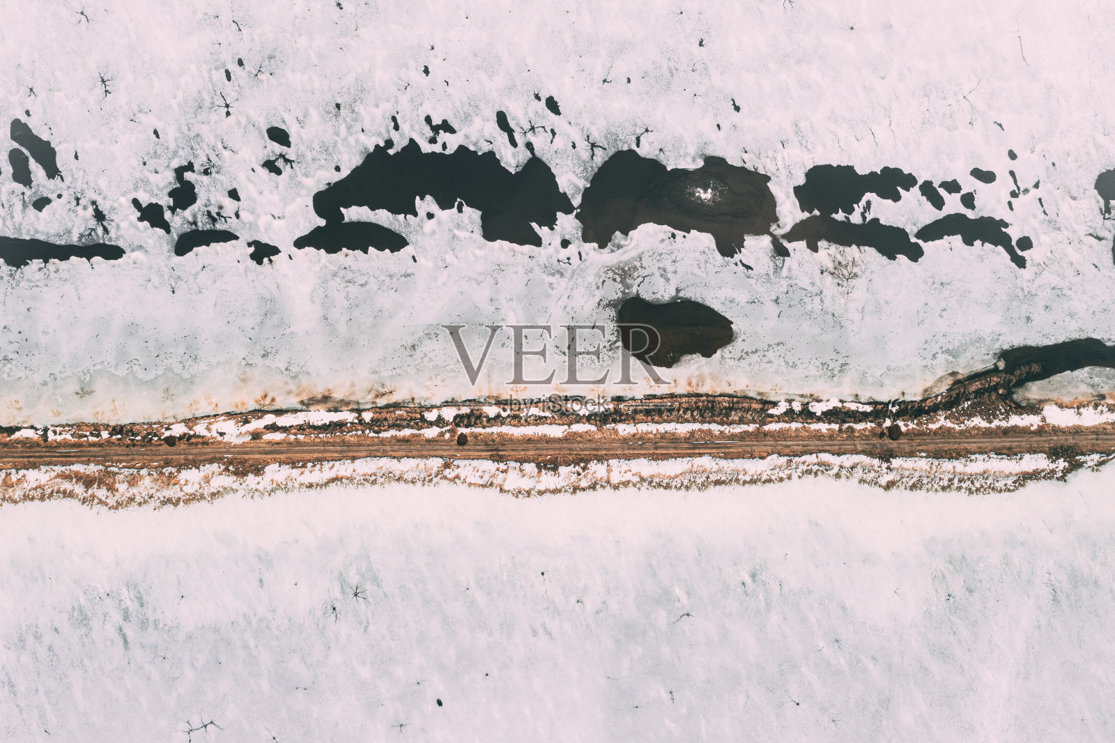 鸟瞰图的道路通过池塘在冬季雪景。白俄罗斯南部的冰冻鱼塘。从高处俯瞰养鱼场。无人机的观点。鸟瞰照片摄影图片