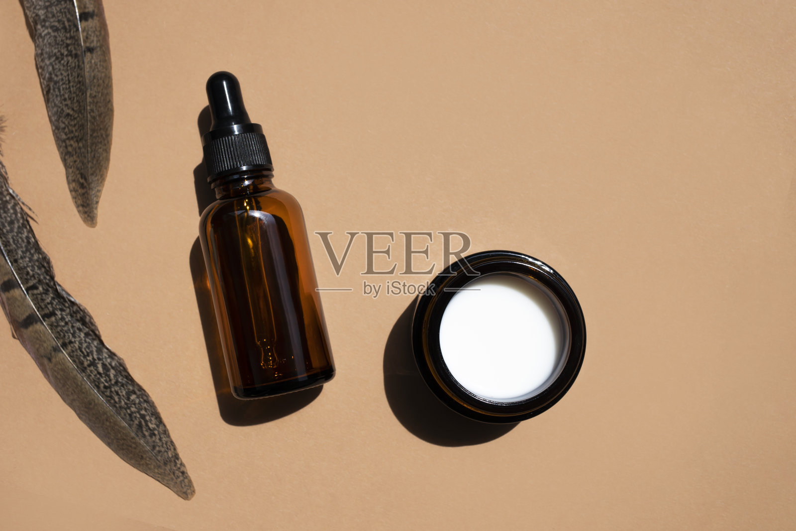 带有滴管的化妆品或药瓶和米色背景上的一罐药膏。顶部视图，放置文本。照片摄影图片