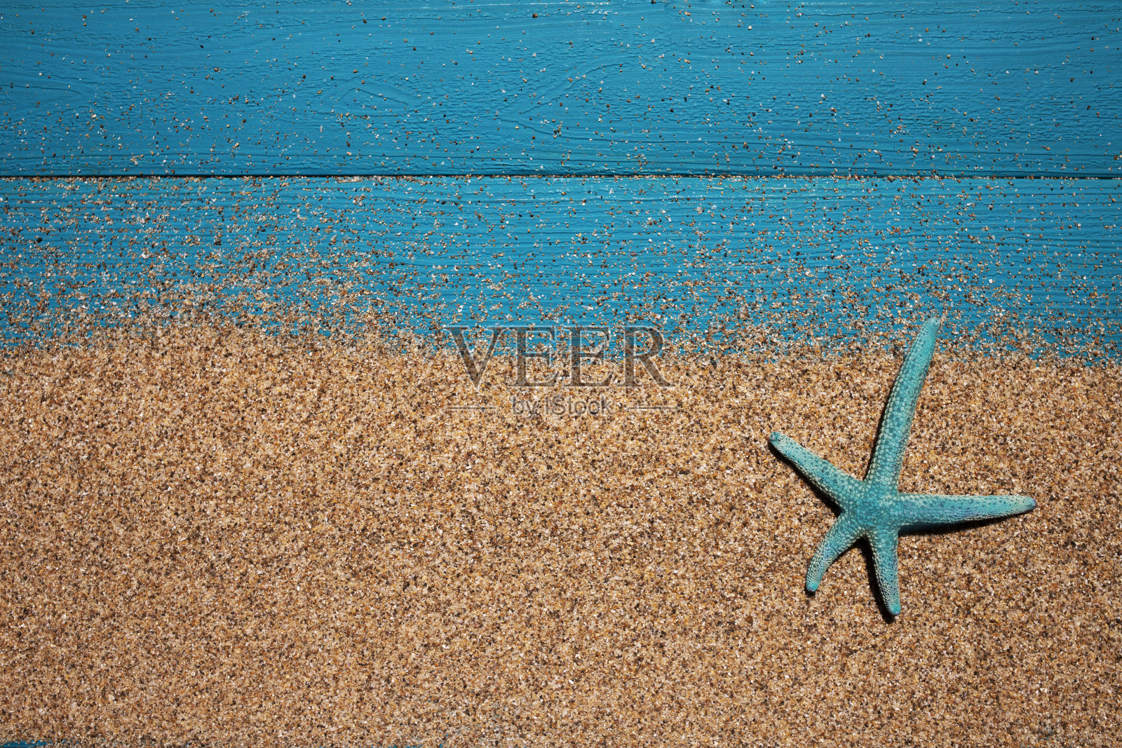 夏天的背景。蓝色的木头背景上有海星和沙子。顶部视图，放置文本照片摄影图片