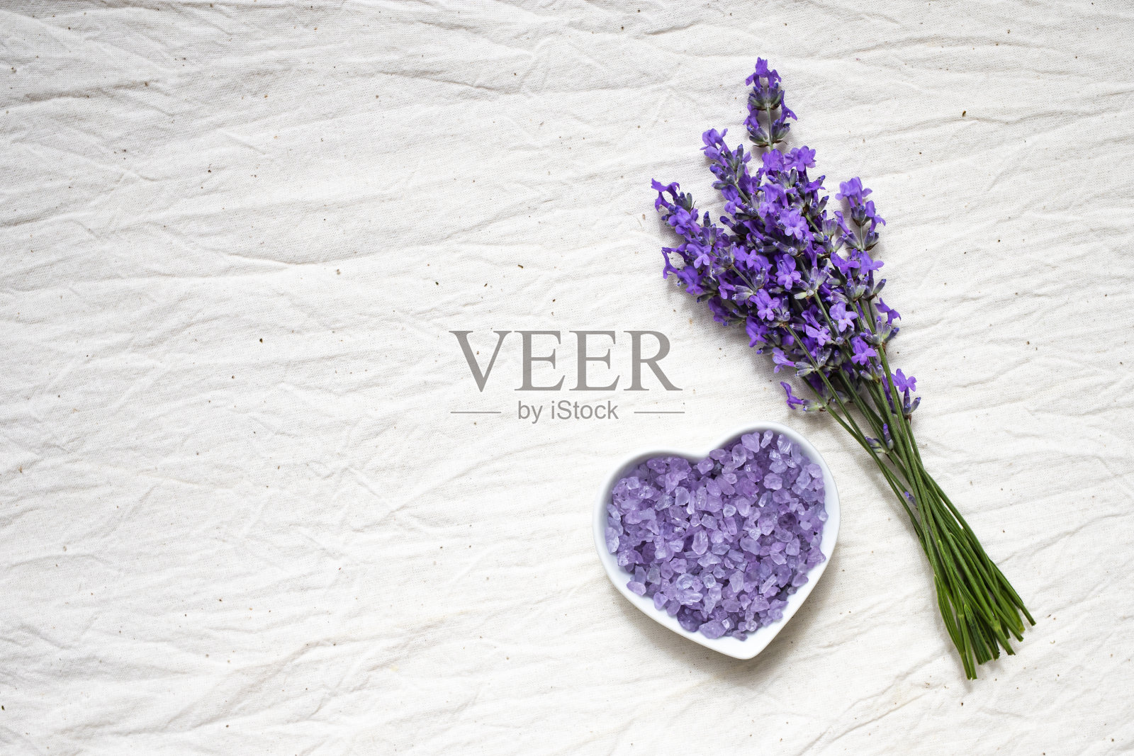 心形薰衣草温泉盐，天然薰衣草花束。皮肤护理的概念。平的。照片摄影图片