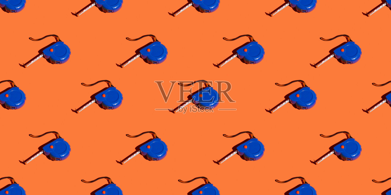 用卷尺测量橙色背景，图案，阴影。施工工具,维修。设计背景。照片摄影图片