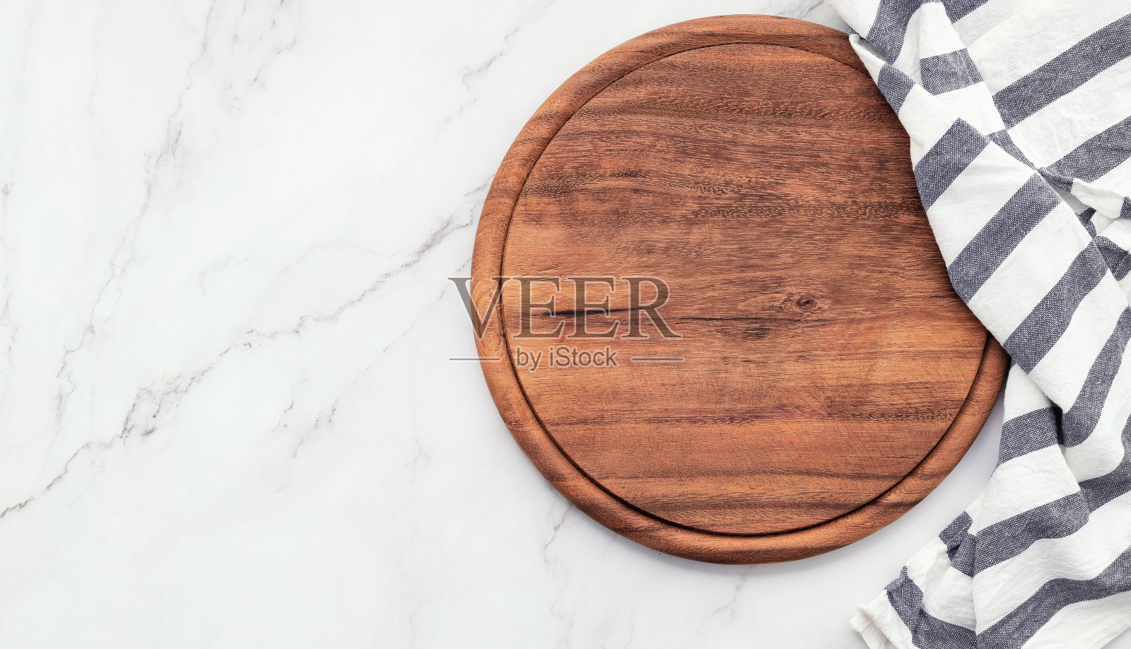 大理石餐桌上放着空的木制披萨盘和餐巾。白色大理石背景上的披萨板和桌布。照片摄影图片