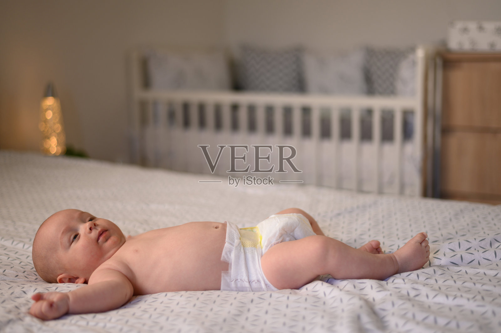 可爱可爱的宝宝躺在床上照片摄影图片