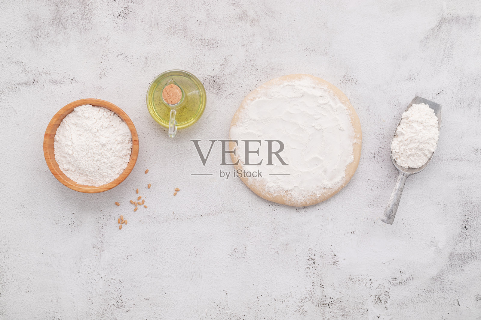 自制披萨面团的原料由小麦穗子、小麦粉和麦粒组成，以白色混凝土为背景。照片摄影图片