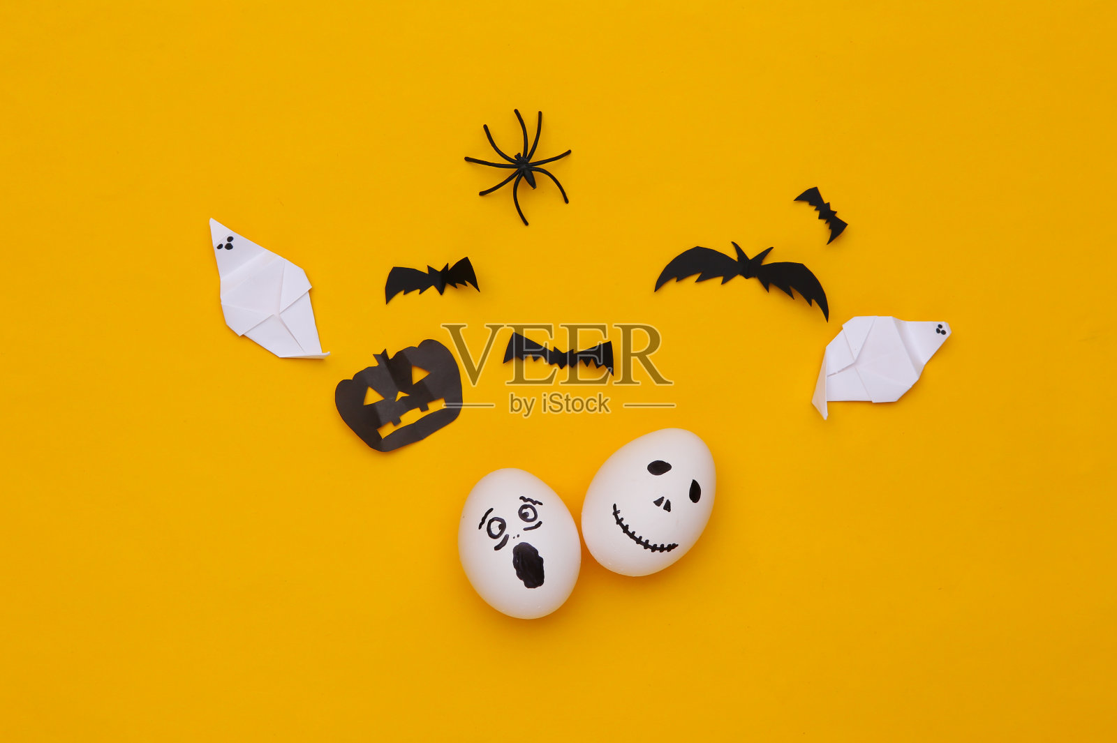 蛋面与万圣节装饰在黄色的背景。俯视图照片摄影图片