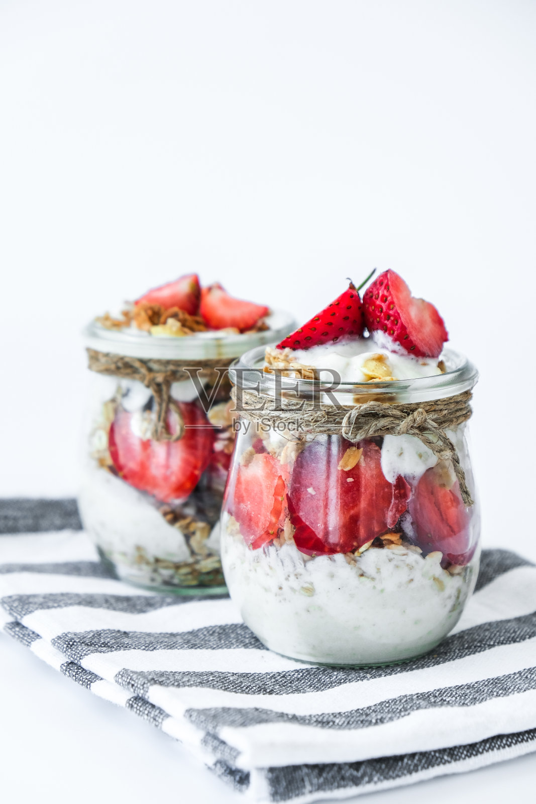 健康的早餐。燕麦格兰诺拉麦片，希腊酸奶，坚果，草莓麦片，在明亮的背景。素食、素食与减肥的饮食概念。排毒菜单照片摄影图片