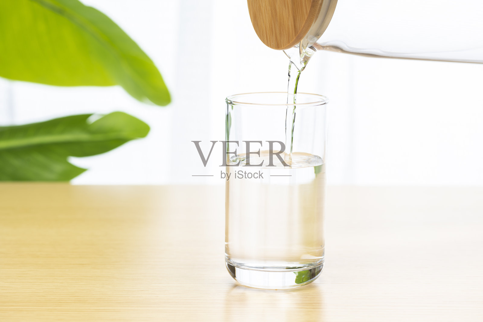 用桌子上的杯子喝水。照片摄影图片